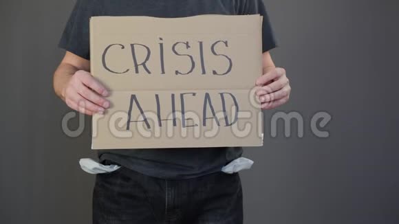 有人拿着纸板上面刻着危机可怜的家伙口袋空空拿着海报危机视频的预览图