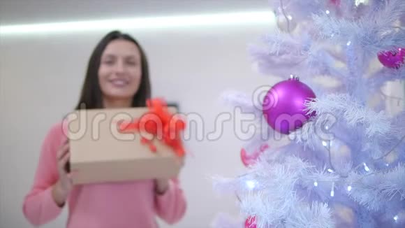 妈妈多么幸福的模糊的时间流逝在圣诞树下为自己找到了一份礼物并把它延伸到相机上视频的预览图