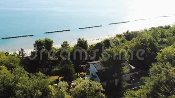 生动的空中拍摄的房子在绿树山令人惊叹的夏季阳光地中海海滩在佩索罗意大利视频的预览图