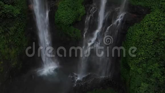 绿色雨林中的瀑布从高空俯瞰瀑布塞库普尔在山上丛林印度尼西亚巴厘视频的预览图