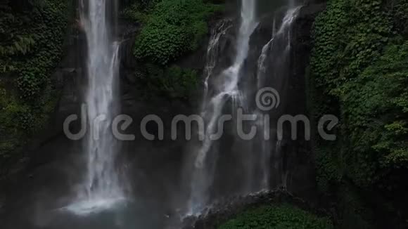关闭绿色雨林中的瀑布在山地丛林中鸟瞰瀑布塞库普尔有人要上去巴厘视频的预览图