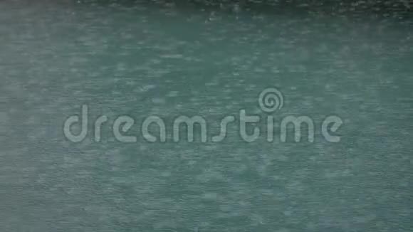 热带夏季雨溅入游泳池在暴风雨和雨滴落进游泳池的时候关闭游泳池视频的预览图