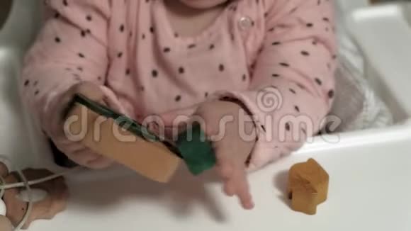 小女孩正在玩一个木制玩具发展良好的运动技能视频的预览图