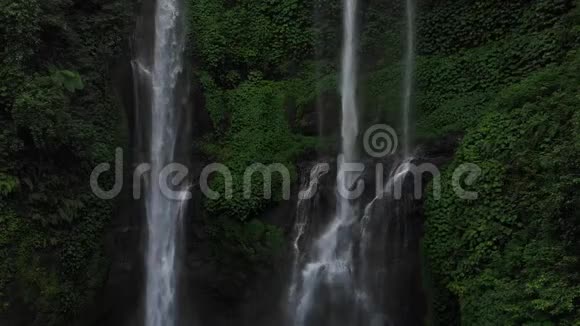 关闭绿色雨林中的瀑布在山地丛林中鸟瞰瀑布塞库普尔有人倒下了巴厘视频的预览图