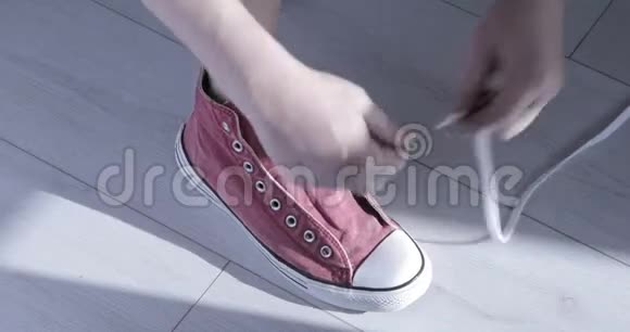 人手系上红色运动鞋视频的预览图