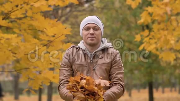 迷人的人在秋天在公园里抛出枫叶情绪好心情视频的预览图
