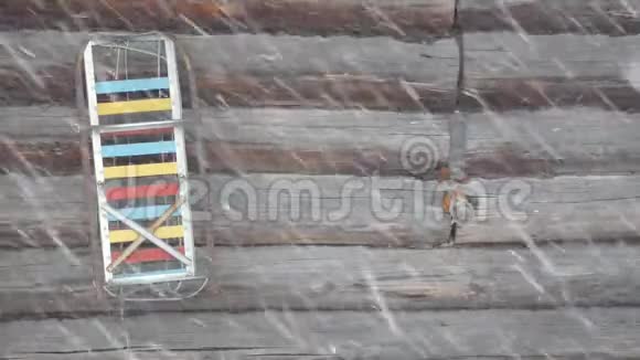 旧雪橇在棕色的木墙上暴雪视频的预览图