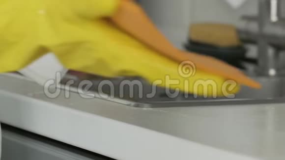 家庭主妇戴黄色手套用橙色抹布和洗涤剂洗桌子视频的预览图