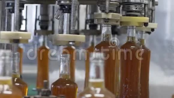 在工厂的玻璃瓶中溢出酒精饮料带玻璃瓶的传送带酗酒者的呕吐视频的预览图