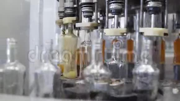 在酒厂的玻璃瓶里溢出布兰迪工厂玻璃瓶灌装机酒精饮料溢漏视频的预览图