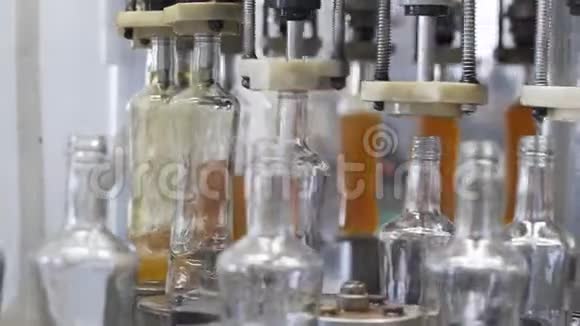 酒厂玻璃瓶中布兰迪溢出的缓慢运动工厂玻璃瓶灌装机a视频的预览图