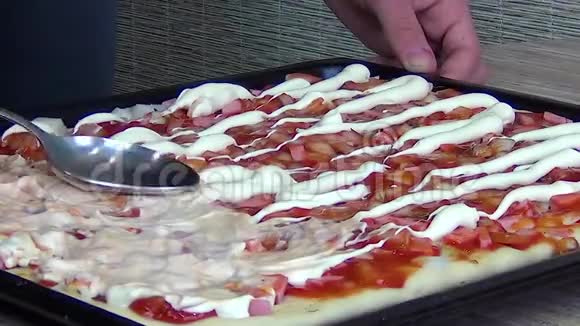 厨师把配料放在生披萨上面准备烘烤视频的预览图