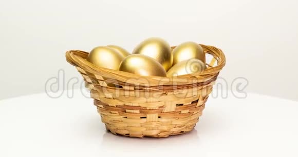 白色背景下篮子里的金蛋金蛋特写复活节春天投资和退休概念视频的预览图