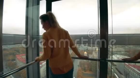 女游客在电梯里看着城市视频的预览图