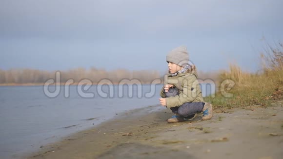 秋天一个小男孩走在河边视频的预览图