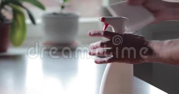 那人手按下防腐喷雾剂把它洒在纸巾上按下红色的按钮慢慢地靠近视频的预览图