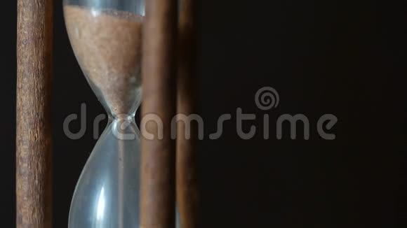 在棕色的深色背景下催眠式的老式沙漏近距离射击视频的预览图