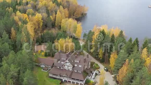 飞越房屋无人驾驶飞机在秋天的乡村与博罗耶湖森林中的大木屋皮尔斯视频的预览图