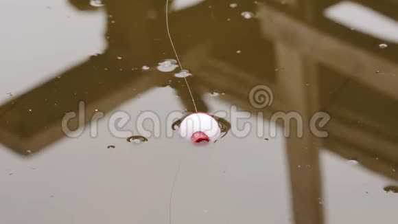钓鱼漂浮在池塘里的波浪上带着一个摇臂的钓具视频的预览图