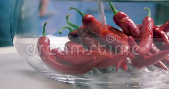 新鲜的热红辣椒用清水清洗和清洗玻璃花瓶素食健康营养食品视频的预览图