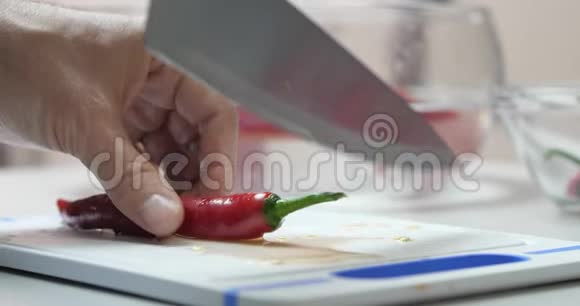 一个厨师的特写手切一个新鲜的热红辣椒辣椒与刀在一个切割板素食健康营养食品视频的预览图