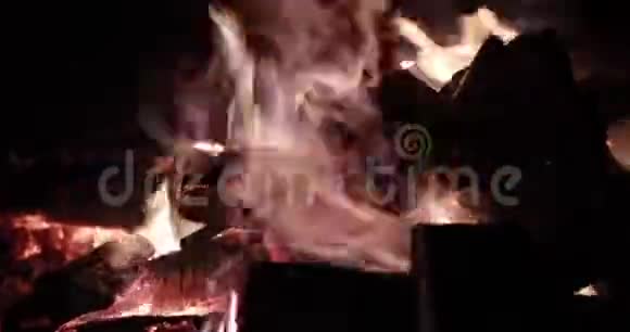 大火在晚上用柴火篝火在晚上燃烧火花火苗是许多红色的木煤视频的预览图