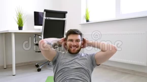 在家做腹肌的男人家庭运动健康生活检疫理念在镜头中微笑的男人视频的预览图