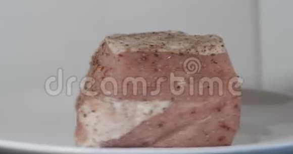 一块新鲜的生猪肉撒上香料并塞满大蒜准备在烤箱里烤视频的预览图