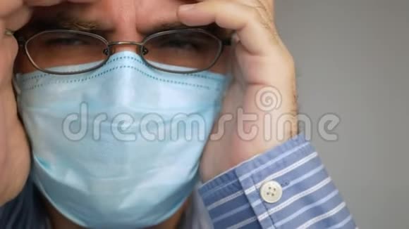 一个悲伤的人脸上戴着防毒面具深呼吸看着病毒惊恐地听到19号新闻视频的预览图
