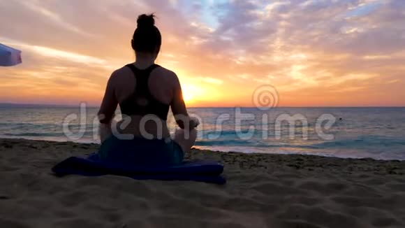 在沙滩上练习瑜伽的女性剪影视频的预览图