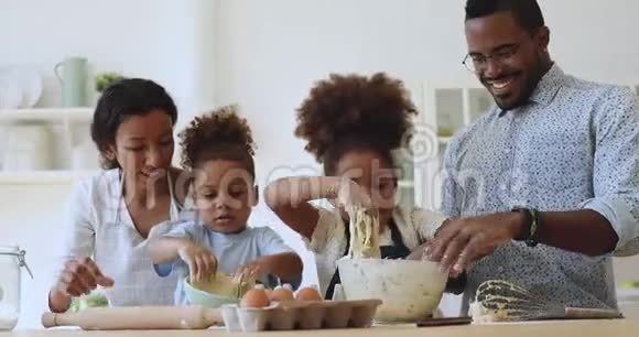 可爱的非洲小孩揉面帮助父母厨房视频的预览图