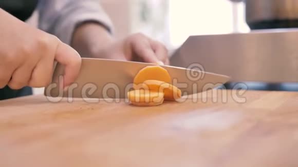 女孩用刀在厨房里切胡萝卜视频的预览图