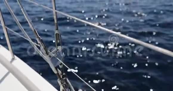 在阳光充足的天气下近距离观看帆船金属电缆桅杆上的滑轮和绳索游艇运动船舶设备视频的预览图