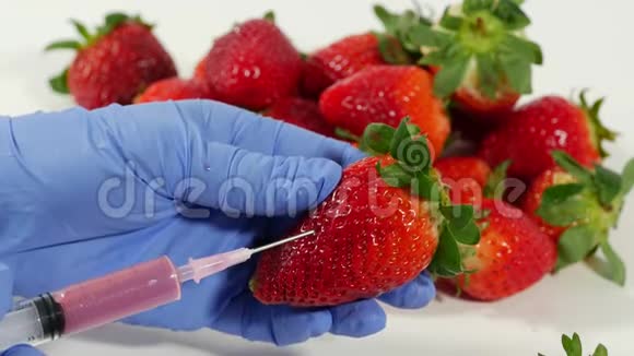戴手套的女人用注射器水果和蔬菜的基因改造视频的预览图
