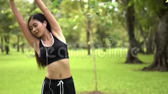 年轻的女跑步者在自然公园锻炼前伸展身体视频的预览图