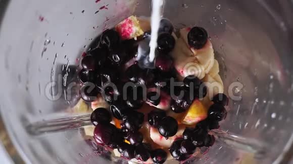 健康食品概念用水果和浆果香蕉冰沙做奶昔把牛奶倒进水果里视频的预览图