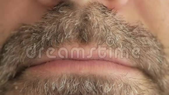 一个留着灰色胡须的人吞下了病毒冠状病毒covid19中的一粒药丸并做了一张痛苦的脸超级宏观特写视频的预览图