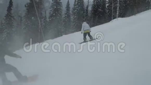 朋友们的慢动作滑雪者从山上骑视频的预览图