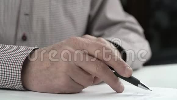 聪明的老人穿着格子衬衫重读信和签名视频的预览图