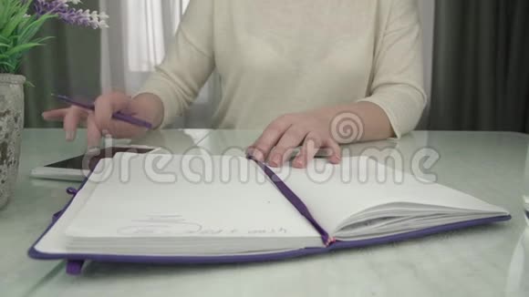 女商人把智能手机写在纸笔上视频的预览图