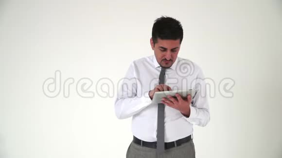 一个长相严肃的东方人正在用平板电脑打字若有所思地挠着下巴视频的预览图