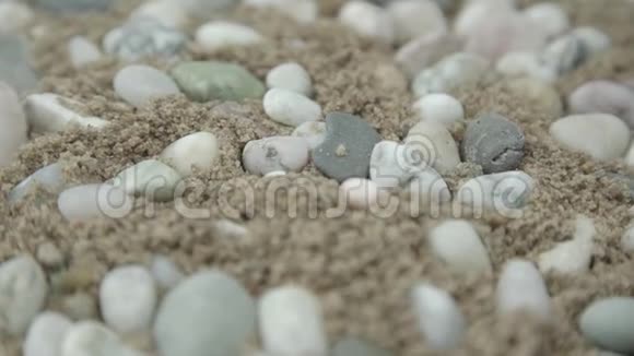 奇妙的卵石岩石躺在黄湿的沙子上旋转视频的预览图