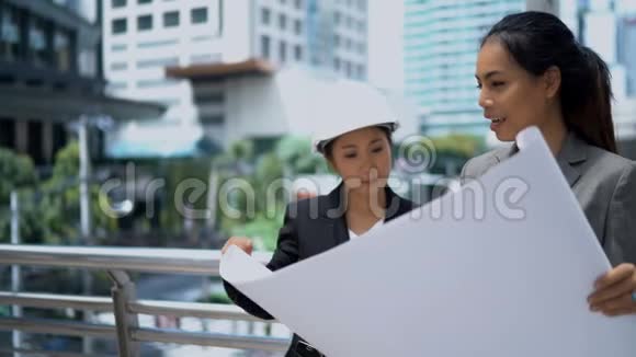 两位年轻女性在检查蓝图和谈话无线电通讯视频的预览图