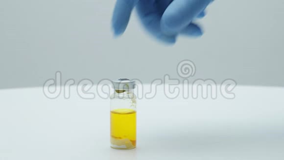 科学家医生双手戴着蓝色手套手里握着玻璃球门诊疫苗接种视频的预览图