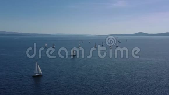 帆船比赛的空中镜头帆船比赛激烈的比赛很多白色的帆岛在背景上视频的预览图