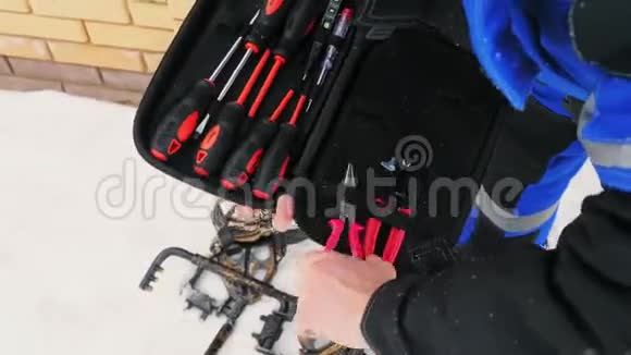 电工从箱子里拿钳子修理设备视频的预览图