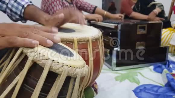 近距离拍摄双手演奏印度古典音乐乐器塔布拉和背景中的口琴演奏视频的预览图