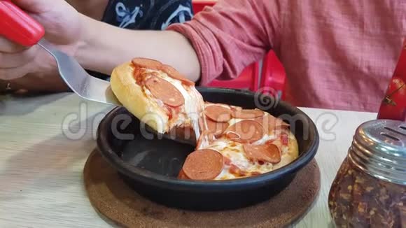 用刀子切一个意大利辣香肠平底锅披萨然后举起一片上面有奶酪和馅皮视频的预览图