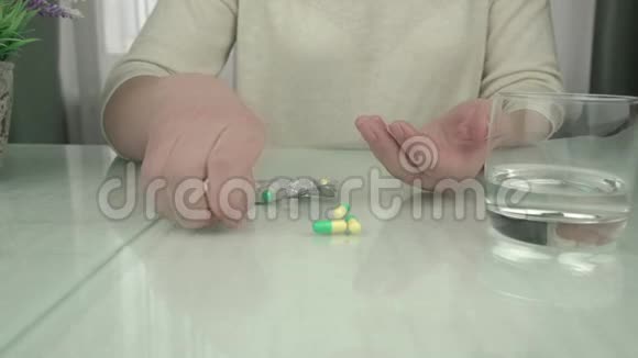 女士手里拿着彩色药丸和水喝视频的预览图