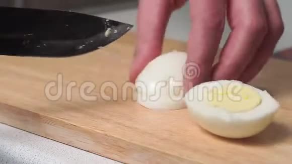 在家里的厨房里人们用一把大刀把煮好的鸡蛋切成圆圈家庭烹饪沙拉视频的预览图